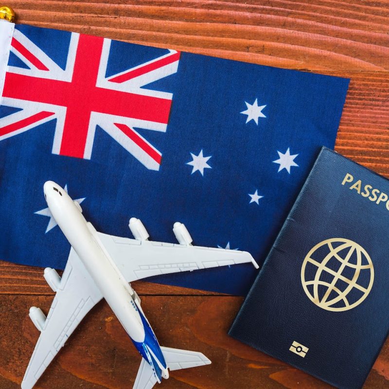 Flag of Australia with passport and toy airplane on wooden background. Flight travel concept ; Shutterstock ID 2004249776; other: -; purchase_order: -; client: -; job: -